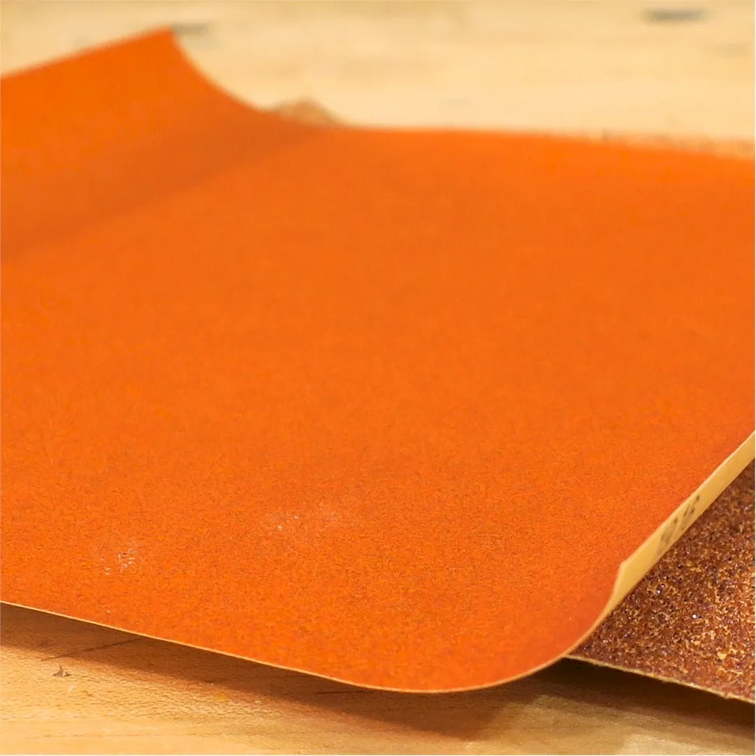 A sheet of sandpaper with sides curling upward